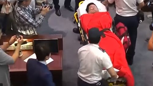 VIDEO Parlamentar scos pe targă în Hong Kong. O dezbatere pe tema extrădării în China s-a terminat cu îmbrânceli
