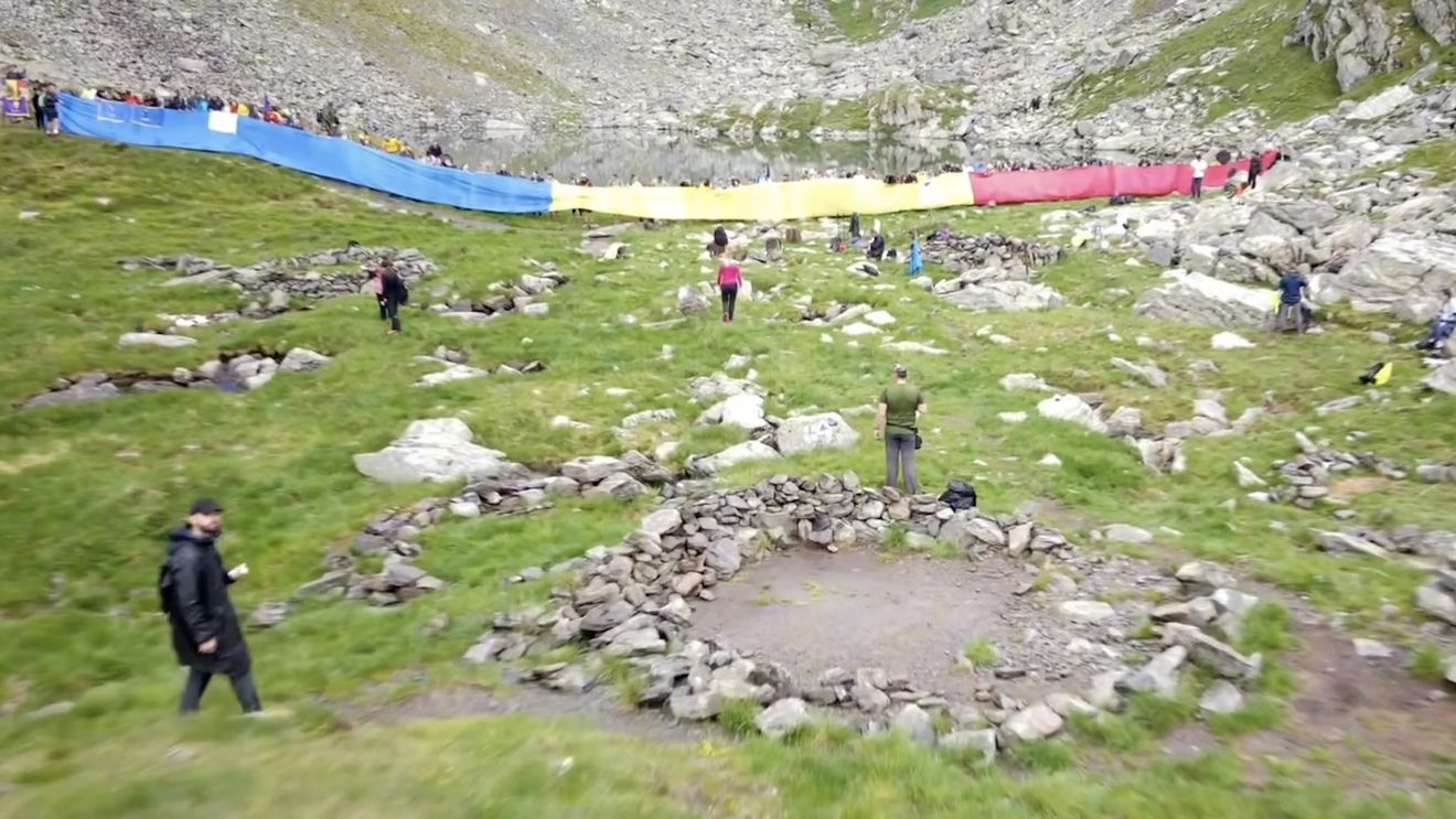 VIDEO Invictus: Peste 100 de militari și civili  au desfășurat un drapel de 100 de metri la Lacul Călțun / ”Au ales ca, prin ascensiunea pe vârful Negoiu, să onoreze simbolul nostru național”