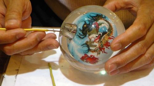 Globuri cu sticlă de Murano, decorate cu foiţă de aur şi argint, produse de o fabrică din Arad / Meşterii sticlari de aici sunt formaţi în ateliere din Italia