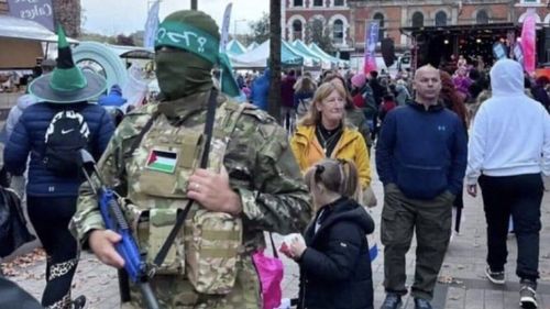 Poliția din Irlanda de Nord crede că fotografia unui bărbat cu un costum Hamas la o paradă de Halloween ar putea fi generată de inteligenta artificiala