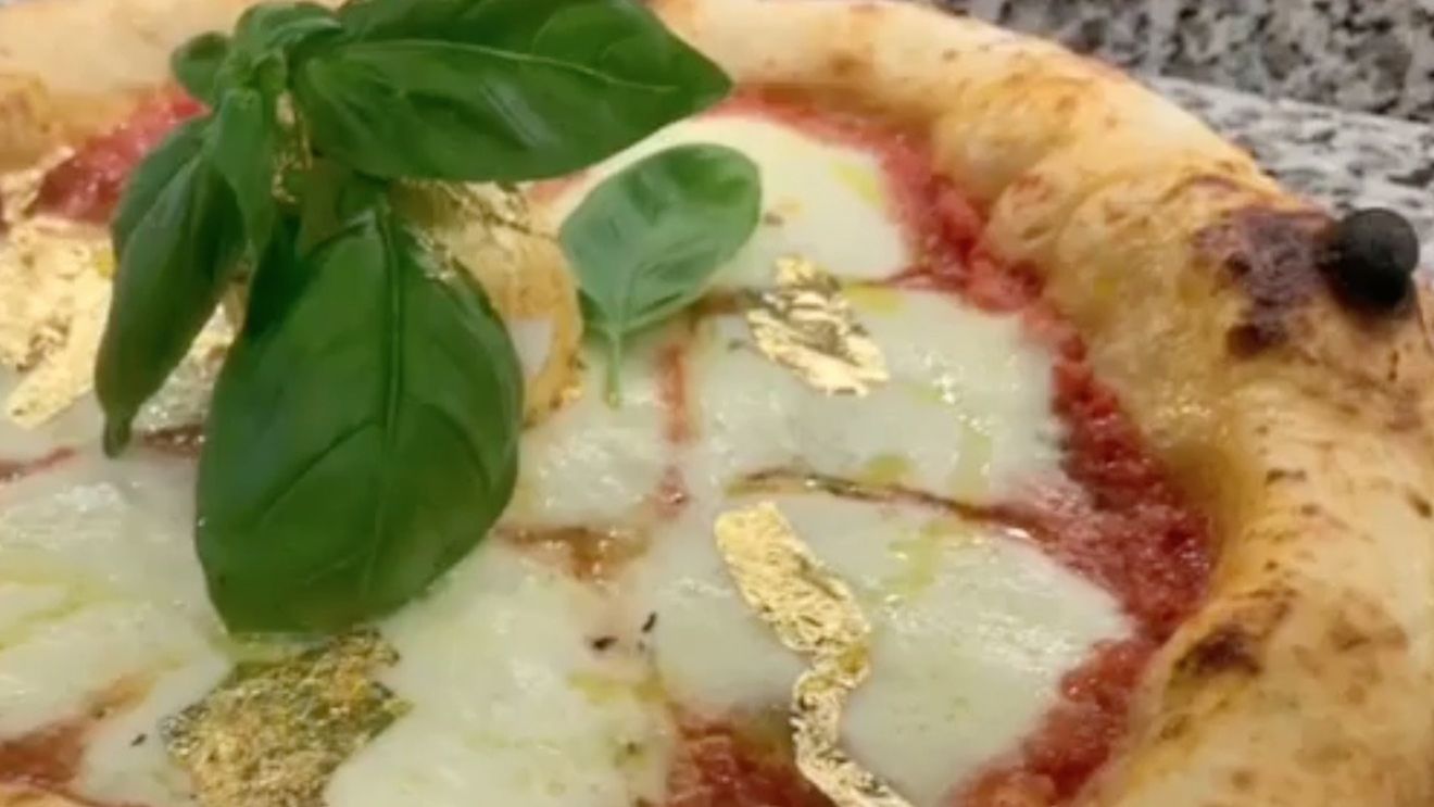 VIDEO Un român a făcut în Italia primele pizza cu foiță de aur / Le vinde cu 99 de euro, iar fiecare comandă e acompaniată cu melodia "We Are the Champions"