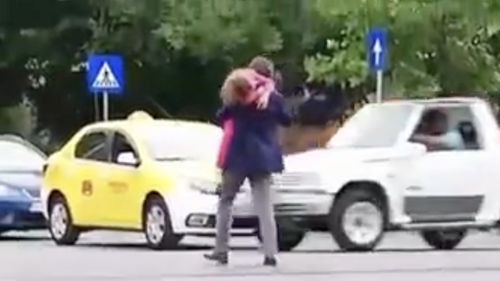 VIDEO Europol: Primarul Nicușor Dan, surprins de camere cu fiica în brațe traversând strada în mod periculos, printr-un loc nepermis
