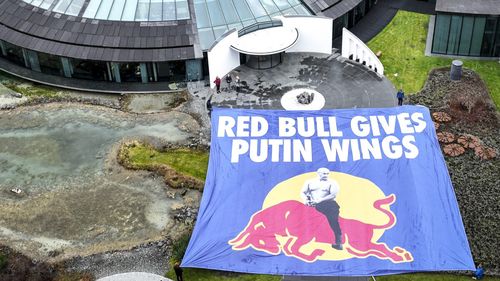 Un grup de activiști a desfășurat un banner de 400 mp în fața sediului central al companiei Red Bull, criticată pentru că nu își retrage produsele din Rusia: „Red Bull îi dă aripi lui Putin”