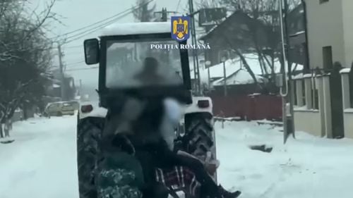 VIDEO Bărbat băut surprins de poliţişti când trăgea cu tractorul pe stradă mai multe sănii cu copii