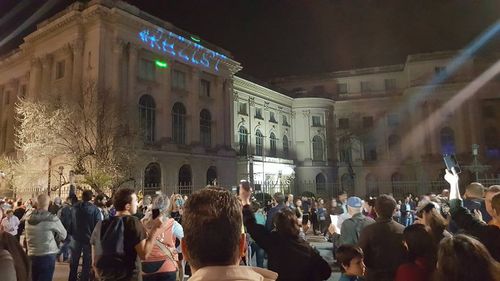 VIDEO Circa o sută de oameni la protestul cu lumini pe Muzeul de Artă în semn de solidaritate cu protestatarul încătuşat de poliţişti