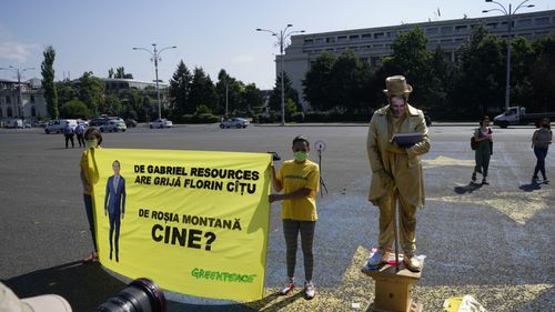 Protest Greenpeace: Statuie vivantă aurită, reprezentându-l pe Florin Cîțu, dezvelită în Piața Victoriei/ Guvernul: Informațiile referitoare la retragerea dosarului Roșia Montană de la UNESCO sunt false