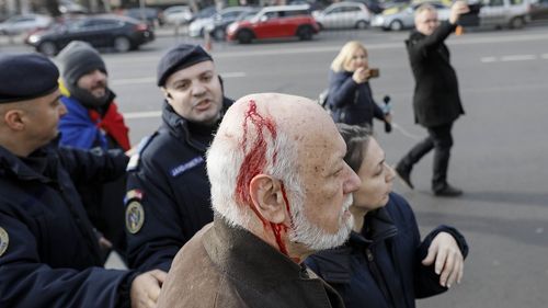 VIDEO Gelu Voican Voiculescu a fost agresat în Piața Universității și a plecat cu capul spart. Voican este judecat pentru crime împotriva umanității