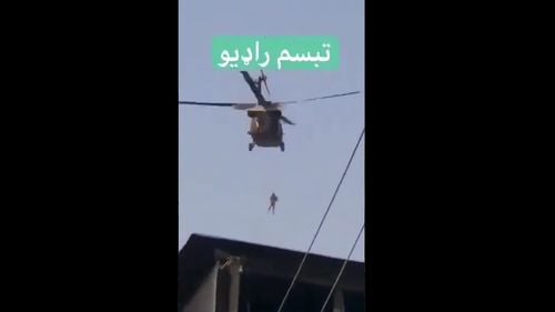 VIDEO Viral pe Twitter, descoperit fake-news: „Omul spânzurat de elicopter” era un taliban care încerca să monteze un steag pe o clădire publică