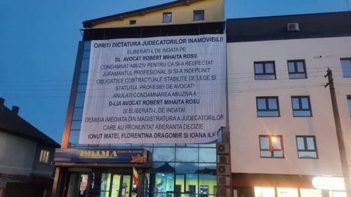Banner uriaș montat pe o clădire din Sibiu cu un mesaj pentru susținerea avocatului Robert Roșu, condamnat la închisoare în dosarul Ferma Băneasa/ Clădirea îi aparține unui avocat care a fost cercetat cu Miron Mitrea în dosarul Aviația Utilitară