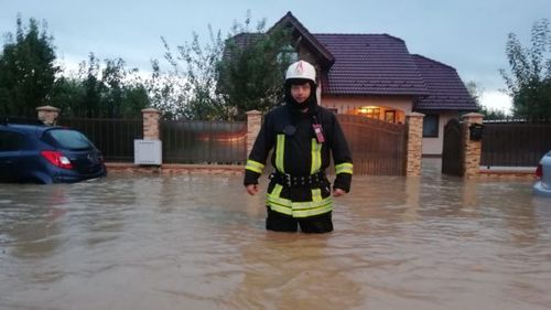 VIDEO Zeci de pompieri şi jandarmi participă la evacuarea apei din mai multe gospodării  dintr-un cartier din Brașov inundat după ce s-a rupt un dig