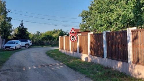 Limitatoare de viteză montate pe un drum de pământ, într-o comună din județul Buzău / Vicepreședintele consiliului județean s-a plâns că-i intră praf în piscină / Îl acuză voalat pe liderul local al USR, care conduce un Porsche, pentru praful din aer