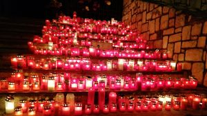 GALERIE FOTO Poarta Spitalului Judetean din Piatra Neamţ, unde și-au pierdut viața 10 pacienți, s-a transformat în altar. Zeci de oameni au aprins candele în memoria victimelor