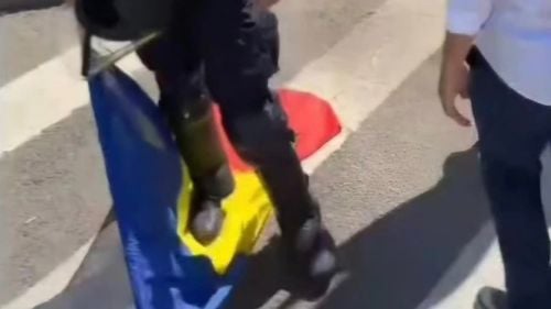 Jandarmeria: Fotografie fake care încearcă să creeze impresia că un jandarm calcă în picioare steagul României / În realitate, jandarmul a ridicat drapelul de pe jos / Site-ul conspiraționist ActiveNews, articol atribuit academicianului Eugen Mihăescu: “ȘOCUL UNEI IMAGINI. Jandarmeria a ajuns să calce în picioare stindardul pe care au depus un jurământ!”