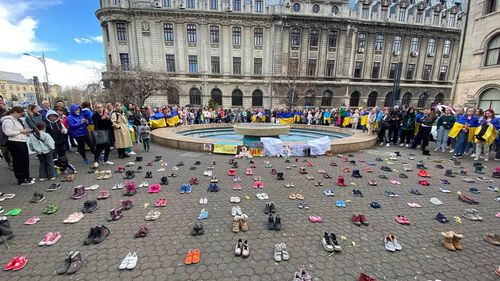 VIDEO Marș pentru Ucraina, în memoria copiilor uciși în război: Peste 200 de pantofi de copii, așezați în Piața Universității