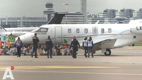 VIDEO Sute de activiști pentru climă îmbrăcați în salopete albe au blocat ore întregi avioanele private pe aeroportul Schiphol din Amsterdam / Peste 100 de activişti au fost arestaţi / Nu au fost raportate întârzieri la zborurile comerciale