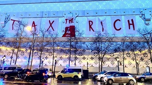 Activiştii Attac au desfăşurat un banner uriaş pe viitorul hotel Vuitton din Paris