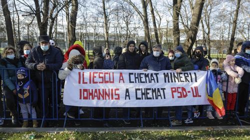 Câțiva participanți la parada de Ziua Națională au afișat un banner critic la adresa președintelui Iohannis și a cooptării PSD la guvernare: „Iliescu a chemat minerii. Iohannis a chemat PSD-ul”