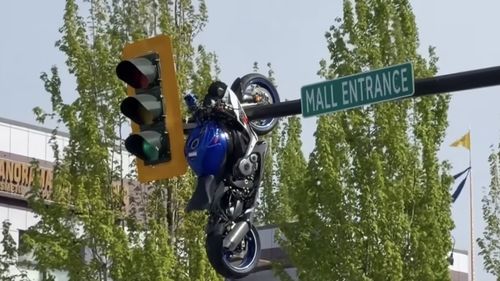 VIDEO O motocicletă a rămas suspendată de un semafor, în urma unui accident, în Canada / „N-am mai văzut niciodată așa ceva, parcă aș fi la film”