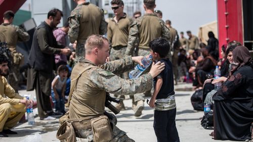 Imagini cu soldații americani care au grijă de copiii lasați de părinți pe aeroportul din Kabul