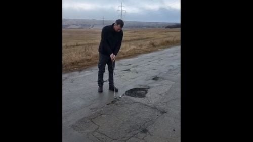 VIDEO Protest inedit în Vaslui: un localnic a jucat golf în găurile din asfalt, cu aluzie la președintele Iohannis