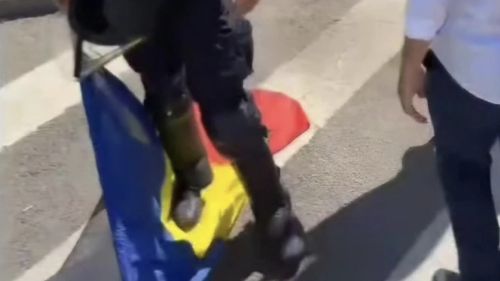 Jandarmeria: Fotografie fake care încearcă să creeze impresia că un jandarm calcă în picioare steagul României / În realitate, jandarmul a ridicat drapelul de pe jos / Site-ul conspiraționist ActiveNews, articol atribuit academicianului Eugen Mihăescu: “ȘOCUL UNEI IMAGINI. Jandarmeria a ajuns să calce în picioare stindardul pe care au depus un jurământ!”