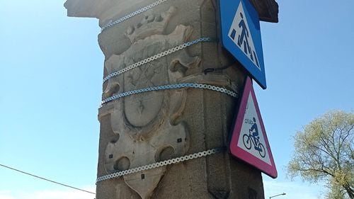 Stema Sibiului de pe monumentul istoric Podul de Piatră, acoperită cu coliere metalice pentru a fixa niște indicatoare rutiere