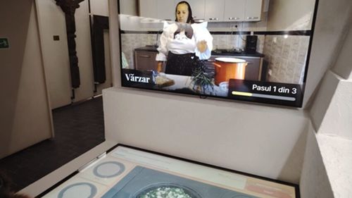VIDEO | Gătit virtual, experiență inedită la Muzeul Etnografic din Sighetu Marmației / Vizitatorii „gătesc” pe o plită care e de fapt un ecran touch, ghidați de socăcițe