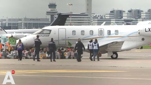 VIDEO Sute de activiști pentru climă îmbrăcați în salopete albe au blocat ore întregi avioanele private pe aeroportul Schiphol din Amsterdam / Peste 100 de activişti au fost arestaţi / Nu au fost raportate întârzieri la zborurile comerciale