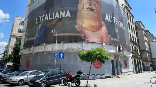 Un afiș publicitar acoperă în întregime o clădire cu risc seismic I de pe Calea Victoriei 220. Trecătorii sunt avertizați că există risc de prăbușire/ UPDATE Intermediarul afacerii este o firmă deținută în asociere de un consilier general PNL și condusă de soția șefului Companiei municipale de consolidări seismice, Răzvan Munteanu