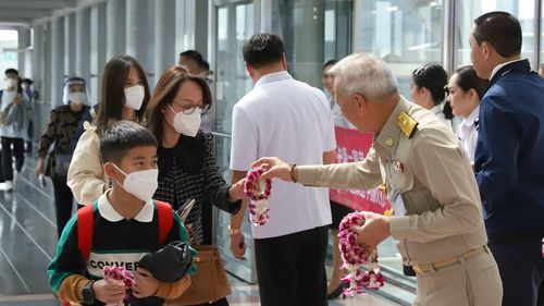 FOTO Revenirea turiştilor chinezi în Thailanda, întâmpinată cu flori şi măşti sanitare