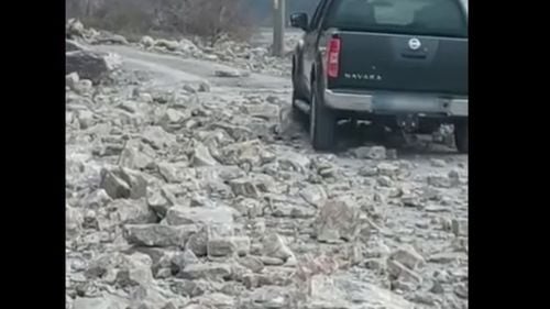 VIDEO Șoferii circulă în continuare pe un drum național închis, în Caraș Severin, în ciuda faptului că în zonă cad stânci / Oamenii curăță singuri bolovanii de pe carosabil 