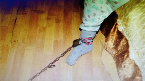 Femeie arestată la domiciliu pentru lipsire de libertate după ce şi-a legat nepoata cu un lanţ de piciorul patului