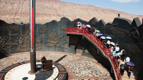 Turiștii chinezi se înghesuie la „Munții Înflăcărați” pentru a experimenta temperaturile extreme de 80 de grade Celsius