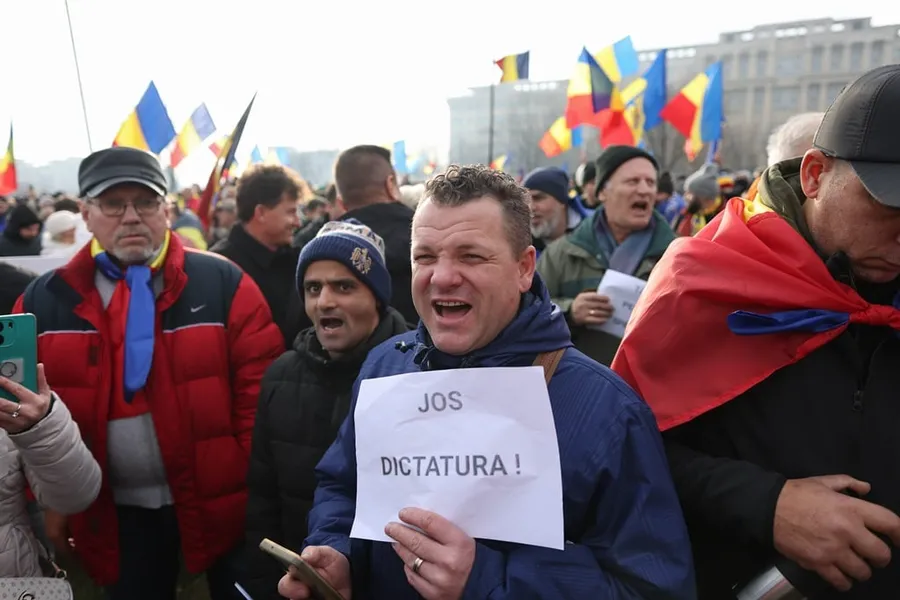 susținătorii lui Călin Georgescu protestează la Palatul Parlamentului în fața Curții Constituțioanle cu pancarte pe care scrie jos dictatura