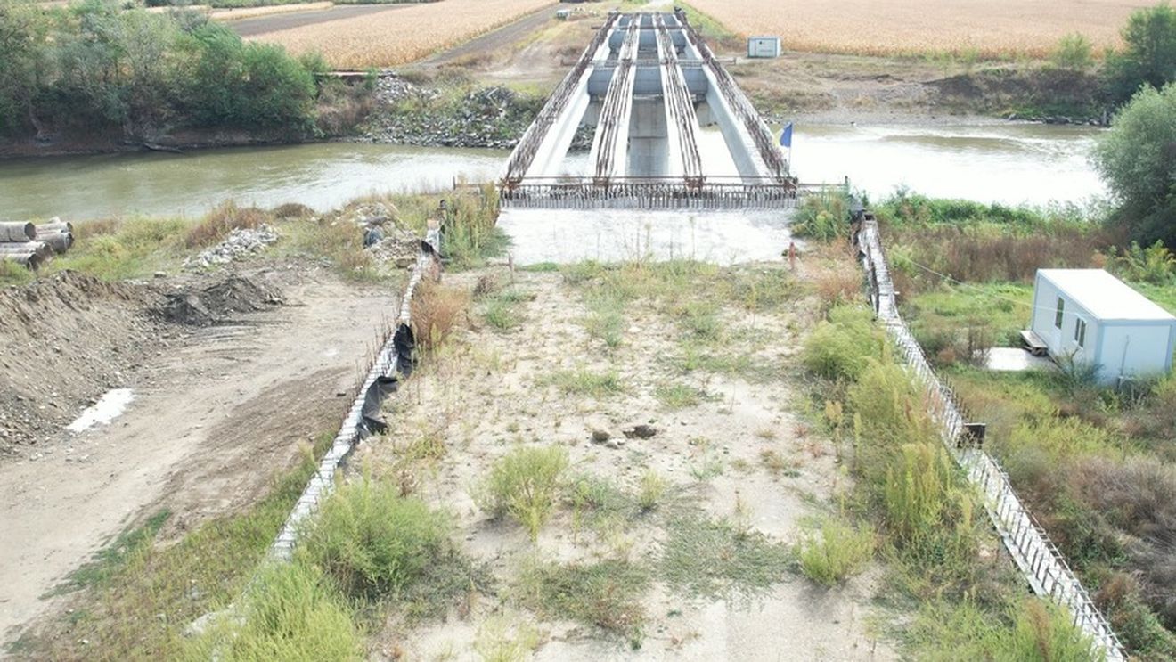 Şantierul unui pod peste Mureş, finanţat prin PNDL, năpădit de buruieni la cinci ani de la licitaţia pentru atribuirea contractului / Localnicii ocolesc mai  mulți kilometri pentru a ajunge la Cugir sau Alba Iulia