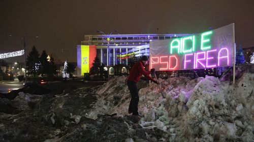 Mormanul de zăpadă murdară din fața Guvernului, decorat cu mesajul luminos ”Aici e PSD Firea”